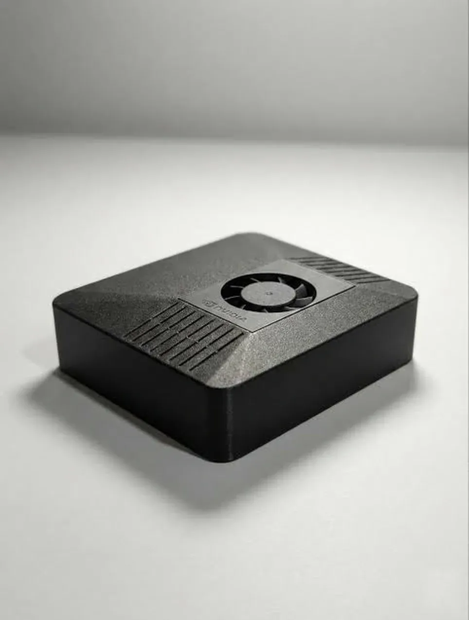 The HermesBox unit photographed from above, showing the ventilation fins and cooling fan.